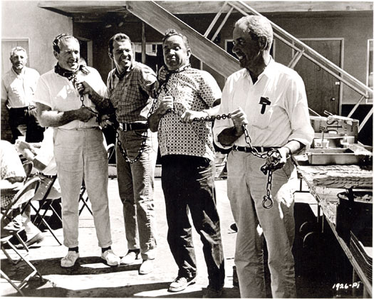 Audie Murphy (second from left) clowns around with some crew members between scenes of “Showdown” (‘63 Universal). The badman of the script, Harold J. Stone, watches in the background.