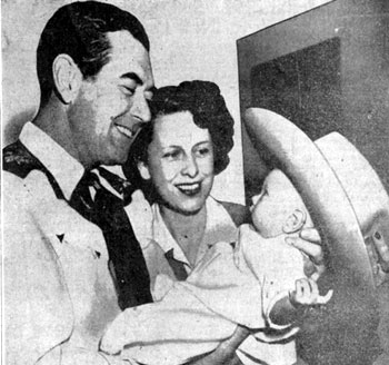 Johnny Mack and Connie Brown hold 3-week old daughter Sally who seems to be trying on one of her Daddy’s cowboy hats. Sally was born September 14, 1946.