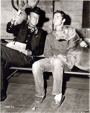 Audie Murphy and Dan Duryea try to rehearse their lines but are interrupted by Audie’s dog Long John, a gift from and names for John Huston, on the set of “Ride Clear of Diablo” (‘53 Universal-International).