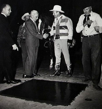 Gene Autry is congratulated by Sid Grauman as Gene is about to be inducted into the Walk of Fame in front of Graunman’s Chinese Theatre on Dec. 23, 1949. Gene’s were the 89th set of hand prints left in the Forecourt of the Stars. (Thanx to Bobby Copeland.)
