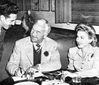 Bill Boyd and wife Grace Bradley sign an autograph for a fan while dining at the popular Brown Derby restaurant in L.A. 