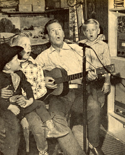 Rex Allen’s sons Mark, Chico (Rex Jr.) and Curtis harmonize with dad as Rex records a song on a tape recorder.