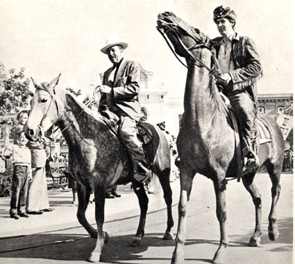 Fess Parker, in his Davy Crockett garb, takes a ride around Disneyland with Uncle Walt Disney.