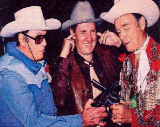 Pat Buttram clowns around as Clayton Moore (The Lone Ranger) and Roy Rogers compare six-guns.