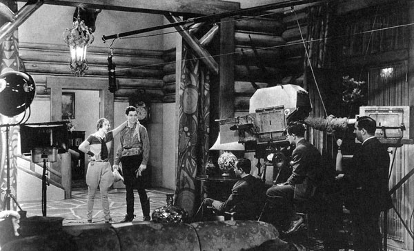 Joan Crawford and Johnny Mack Brown on the set for MGM’s “Montana Moon” (‘30). Producer/director Malcolm St. Clair is seated by the camera. (Thanx to Jerry Whittington.)