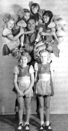 Ray “Crash” Corrigan demonstrates his strength with the Meglin Kiddies while filming The Three Mesquiteers “Roarin’ Lead” (‘36 Republic).