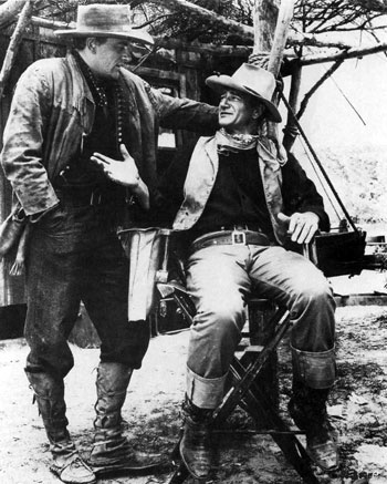 James Arness and John Wayne talk things over during a break in the making of “Hondo”. (‘53 WB). (Thanx to Jerry Whittington.)