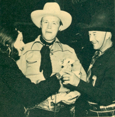 There's snacks all around for Rosemary Lane (?), Wayne Morris and William Boyd as Hopalong Cassidy at the premiere of Warner Bros. "Virginia City" in early 1940 in Reno, NV.