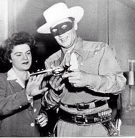 Radio Lone Ranger Brace Beemer shows his pistol to an admirer.