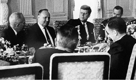 Gene sits with President Kennedy for an unknown event.