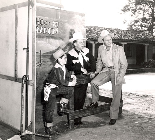 Youngster Steve Salina asks Hoot Gibson questions about old cowboy films which Hoot discusses and shows during a filmed but apparently never released June 1950 TV series. Hoot also had guests drop by such as Rand Brooks pictured here. Hoot did host a series of 15 minute TV programs promoting the sale of Aristo Blue Chinchillas. Music was included by the Jimmie Haskell Trio. That show was aired and I have several of those which appear to have all been filmed at the same time.