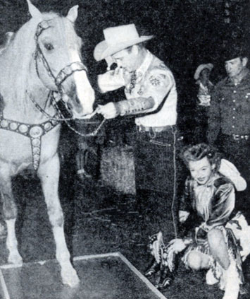 Roy Rogers and Dale Evans assist Trigger in putting his hoofprints in cement at the old Hitching Post theatre in L.A.