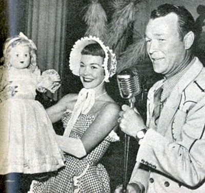 Roy Rogers helps Jane Wyman auction off one of her dolls at the Christmas 1950 Chuck Wagon Whoop De Do at the Beverly Hills Hotel. $30,000 was raised for the building fund of a nursery school for visually handicapped children. The doll sold for $950 to restauranteur Mike Romanoff.