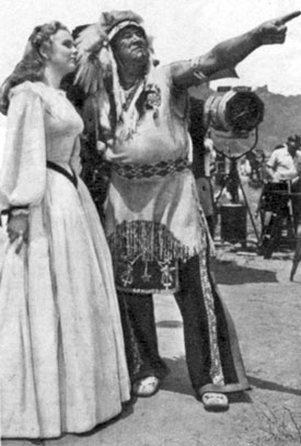 Songstress Deanna Durbin on the set of “Can’t Help Singing” (‘44) with famed Indian athlete Jim Thorpe.