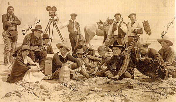 Relaxing between scenes, director John Ford (with glasses), star Harry Carey and players Johnny Tyke, Otto Meyer, Duke Lee and rodeo cowgirl Vera McGinnis. Circa 1917.