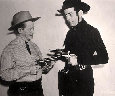 Is that Lash LaRue? No, it’s Humphrey Bogart getting a few pointers on how to handle a six-gun from real life badman Al Jennings in preparation for Bogie’s role in “Oklahoma Kid” (‘39 WB). (Thanx to Bobby Copeland.)
