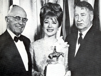 Albert K. Mitchell, one-time president of the American Quarter Horse Association and Chill Wills stand beside Amanda Blake whose performance as Miss Kitty on “Gunsmoke” won her a Wrangler Award for Outstanding Fictional Television Program at the Cowboy Hall of Fame in 1966.