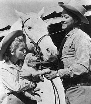 Gloria (Penny) Winters introduces her puppy to Kirby (Sky King) Grant and his horse.