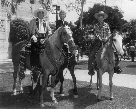 (Above) Will “Sugarfoot” Hutchins was Grand Marshal at the annual Sheriff’s Rodeo in L.A. Coliseum in 1958. (L-R) Hutchins, Sheriff Gene Biscailuz, Barbara Stanwyck and a Sheriff’s Deputy. (Below) Bizcailuz, Stanwyck, Hutchins.