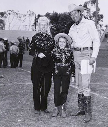 Western tailor Nudie’s wife Bobbie and daughter Barbara pose with Bill Elliott.