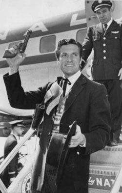 Hugh “Wyatt Earp” O’Brian waves to the crowd as he departs an airplane in the ‘50s. Yep, he got away with guns on an airplane back then.