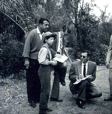 Preparing to shoot a scene for “Buckskin” (‘58) are young star Tommy Nolan and a couple of production people. Singer Tennessee Ernie Ford looks on. “Buckskin” was originally the summer replacement for Tennessee Ernie’s popular TV series.