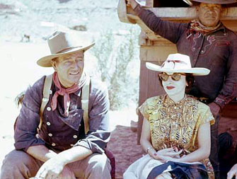John Wayne and his wife Pilar relax on location during the filming of “The Searchers” (‘56). They were married in ‘54.