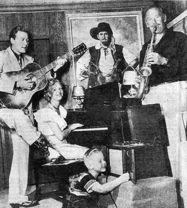 Roy Barcroft on saxophone, Monte Hale on guitar, Roy’s wife on piano with young Michael Barcroft recording the jam session in Barcroft’s home. Note the painting of Barcroft as Captain Mephisto used in the 1945 Republic serial “Manhunt of Mystery Island”. (Photo courtesy Bob Burns and CI.)