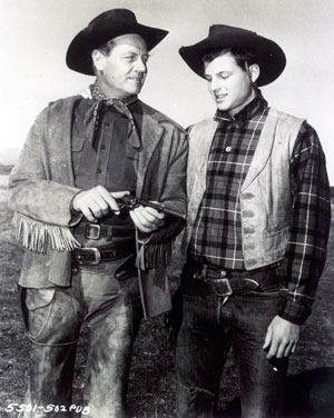 Joel McCrea demonstrates the finer points of his six-shooter to son Jody while
filming “Wichita” (‘55). 
