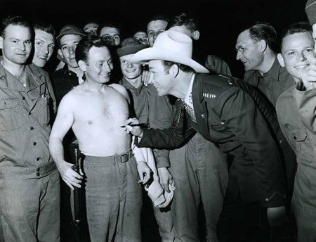 Wonder if this soldier still has the autograph on his chest? Roy Rogers visiting troops in the early ‘40s.