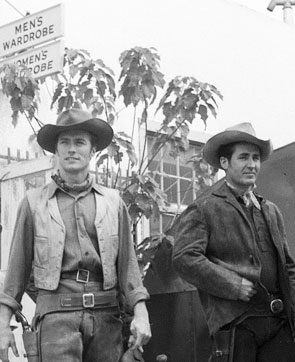 Clint Eastwood and Sheb Wooley emerge from men›s wardrobe ready for action on another episode of “Rawhide”. (Thanx to Terry Cutts.) 
