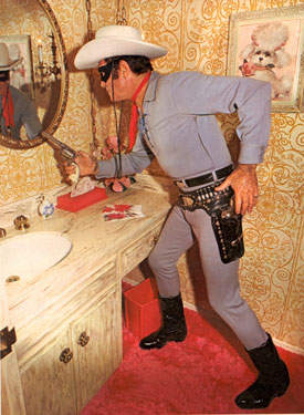 A latter day Clayton Moore (“Lone Ranger”) practices his draw in front of a mirror
in his suburban Hollywood home.