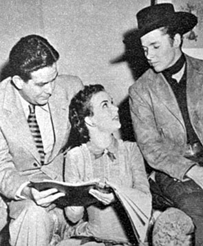 Gale Storm looks over the script for “The Kid From Texas’ (‘50) with producer Paul Short and star Audie Murphy.