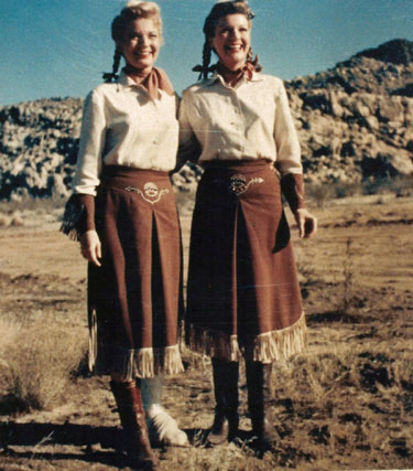 Gail Davis (L) on location with her broken foot stands beside Nan Leslie who stood in for Gail during certain scenes. For our book WESTERNS WOMEN Nan Leslie told writer David Rothel, “While Gail was doing one of the episodes of ‘Annie’, she broke her ankle. Because of our close friendship and because we looked somewhat similar, I volunteered to double her so they could go on with production. They had me do long distrance shots where we could make it appear I was Gail. She was able to do the close-ups where her broken ankle wouldn’t show and where she didn’t have to walk. That was really fun for me! I went along on location and had a ball and didn’t have to worry about lines. All I did was Gail’s walking, mounting and riding of the horse—that sort of thing. At the end of the day, I was the only who got to go out to dinner and dance with the crew while Gail was immobilized. She’s never stopped kidding me about the fun I had while she was ‘suffering’.” (Photo courtesy Dale Price.)