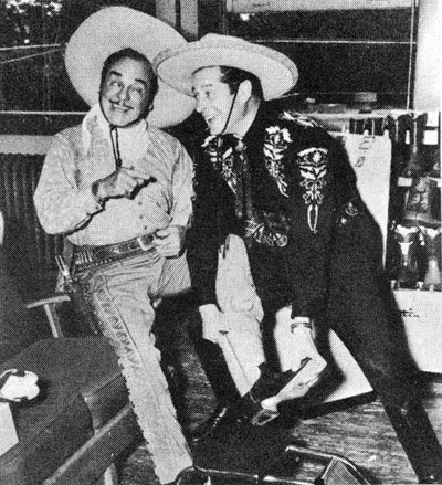 Duncan Renaldo, the Cisco Kid, fits his pal Leo Carrillo, Pancho, with a pair of boots at the Justin Boot plant in Fort Worth, TX, during the company's 75th anniversary in 1954.