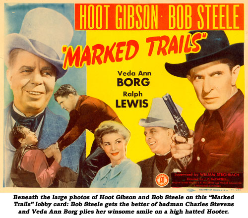 Beneath the large photos of Hoot Gibson and Bob Steele on this "Marked Trails" lobby card: Bob Steele gets the better of badman Charles Stevens and Veda Ann Borg plies her winsome smile on a high hatted Hooter.