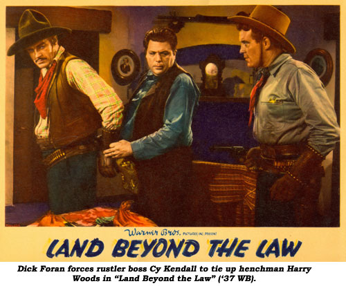 Dick Foran forces rustler boss Cy Kendall to tie up henchman Harry Woods in "Land Beyond the Law" ('37 WB).