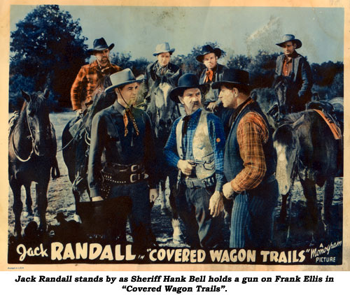Jack Randall stands by as Sheriff Hank Bell holds a gun on Frank Ellis in "Covered Wagon Trails".